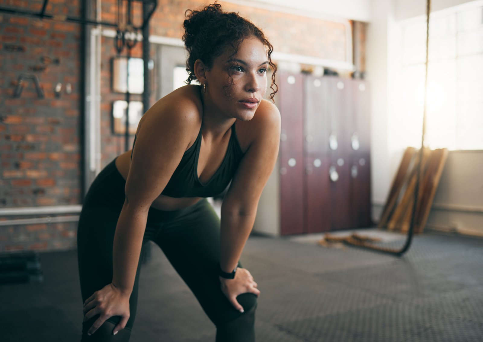 Tired, exercise and woman at gym after fitness workout or training for health and body wellness. Young sports female or athlete resting on break while thinking about goals, progress and performance.